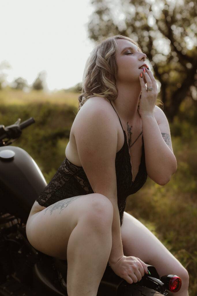 sitting on a motorcycle in a boudoir pose 